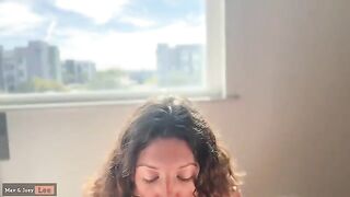 A cute woman fucks in front of the window with her husband
