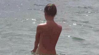 A beautiful naked girl is walking on the beach