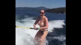 A sexy girl has fun on the water while topless skiing