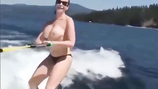 A sexy girl has fun on the water while topless skiing
