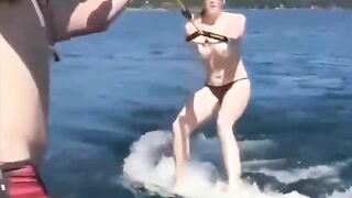 A sexy girl has fun on the water while topless skiing