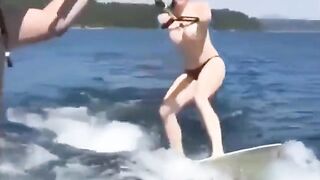 A sexy girl has fun on the water while topless skiing