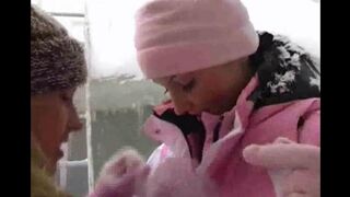 Two beautiful girls having fun in the snow on a cold winter day
