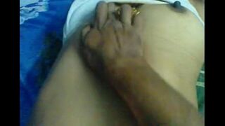 A husband massages the nipples of his wife, exploring sensually