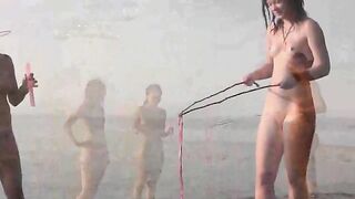 A naked girl is having fun on the beach