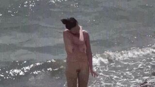 A couple of nudists are enjoying themselves on the beach