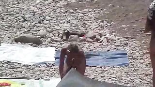 A couple of nudists are enjoying themselves on the beach