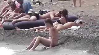 A couple of nudists are enjoying themselves on the beach