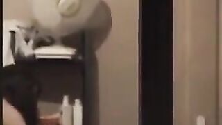 The guy looks at himself in the mirror, admiring his naked body
