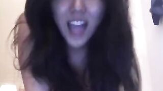An Asian girl caresses herself on her bed in a steamy session
