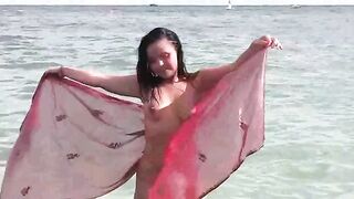 A girl bathes completely naked in the sea, enjoying a free and wild time