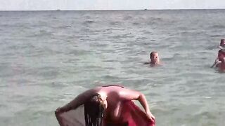 A girl bathes completely naked in the sea, enjoying a free and wild time