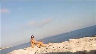 A hot girl is basking in the sun on the beach completely naked