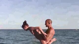 Nude girls are having fun on the beach with acrobatics